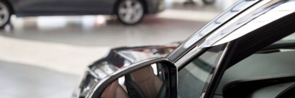 New cars at dealer showroom. Themed blur background with bokeh effect. Car auto dealership. Prestigious vehicles.